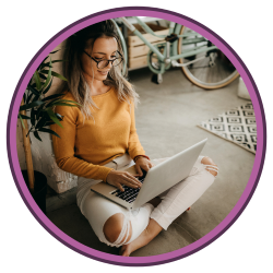 Woman sitting crossed legged typing on laptop