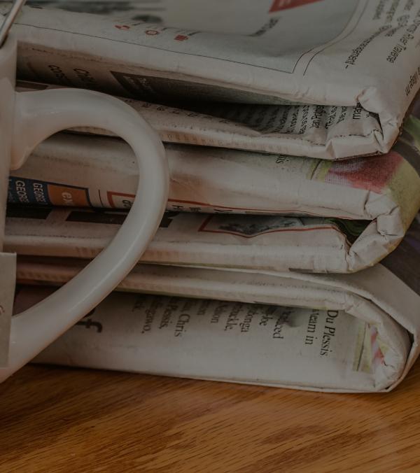 pile of newspapers with a mug handle showing