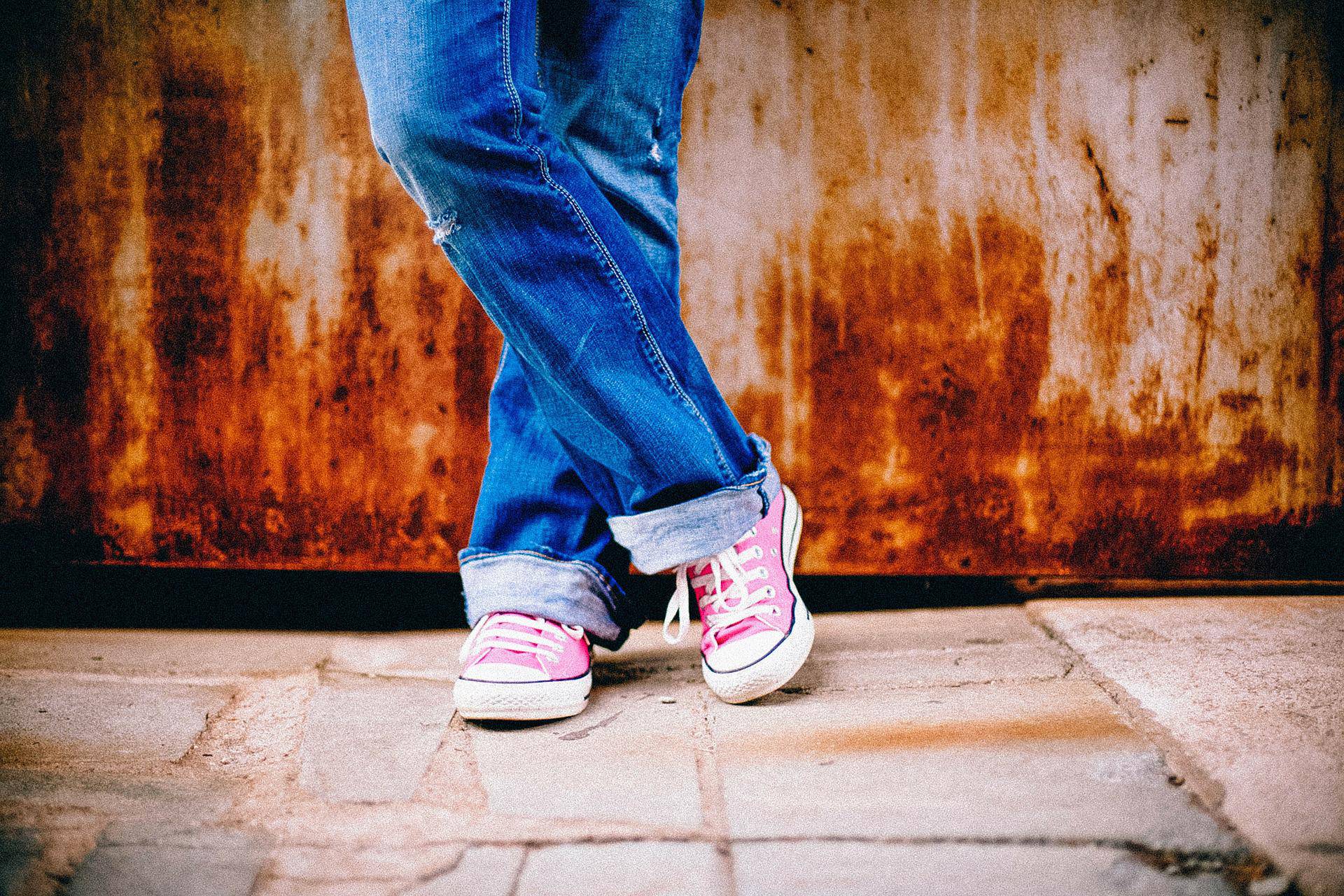 Picture of a young persons legs and feet wearing jeans and trainers